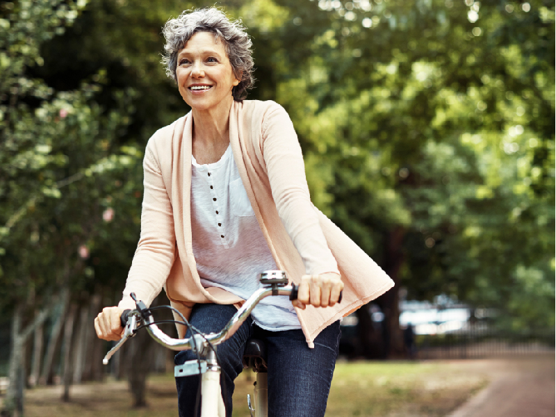 Older woman riding her bike thanks to exceptional orthopaedic care