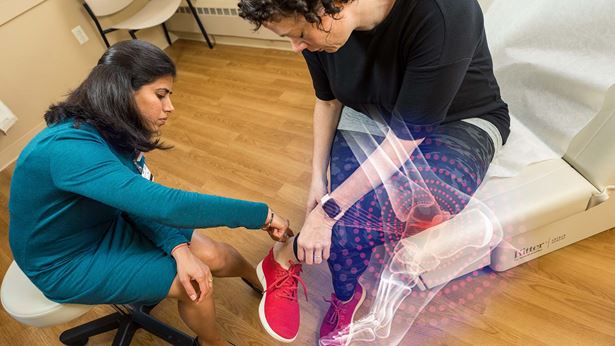 A doctor checks her patient's ankle and foot