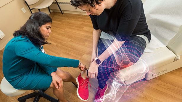 Doctor examines her patient's ankle