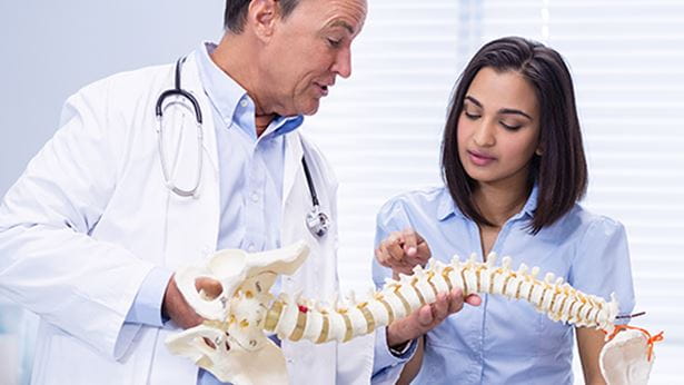 doctor and patient looking at a spine diagram