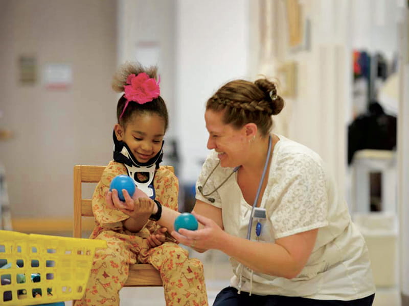 a nurse talking with a child in the hospital