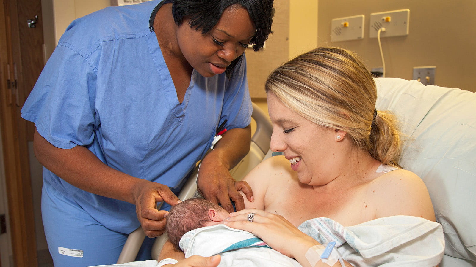 Nurse, newborn baby, and mom in the hospital